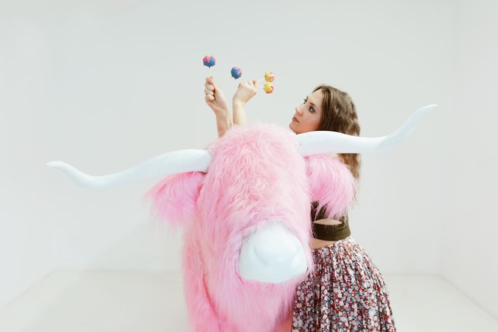 girl in pink and white dress holding pink plush toy