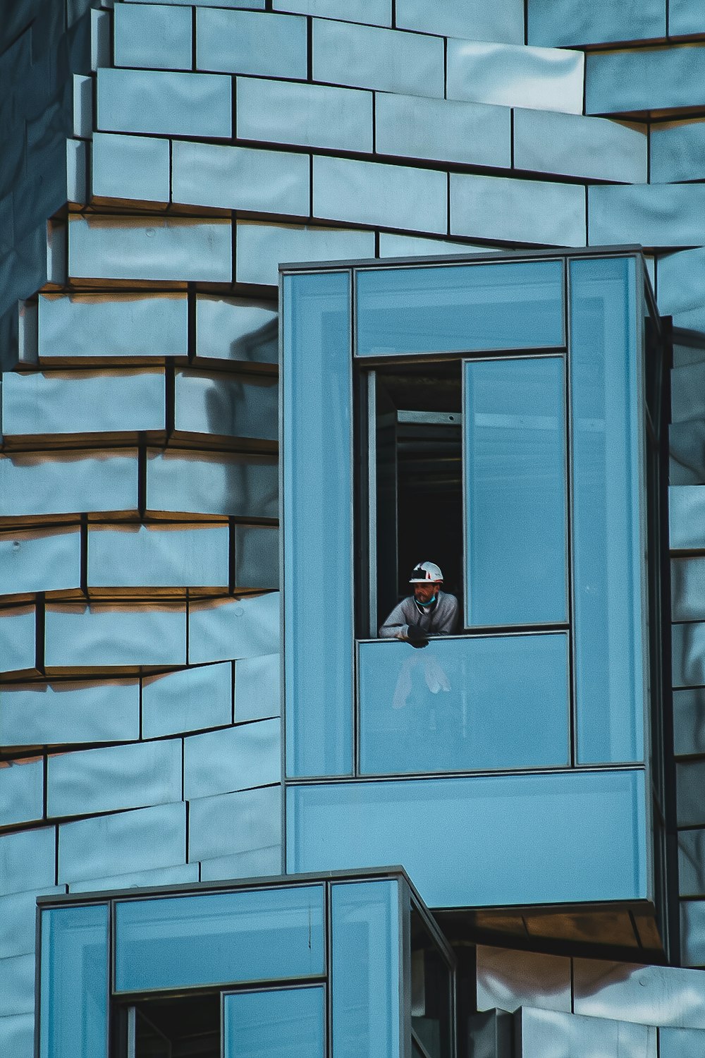 homme en veste noire et pantalon noir debout devant la porte en bois bleu