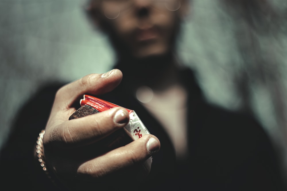 person holding red and white box