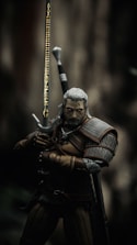 man in black and brown suit holding sword
