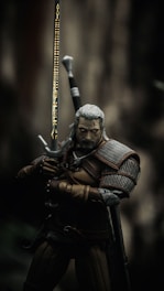 man in black and brown suit holding sword