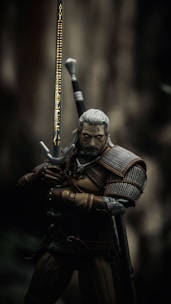 man in black and brown suit holding sword