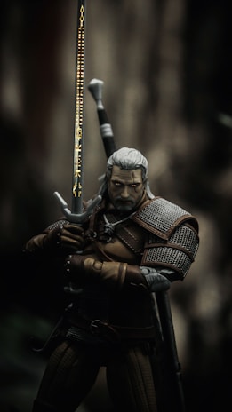 man in black and brown suit holding sword