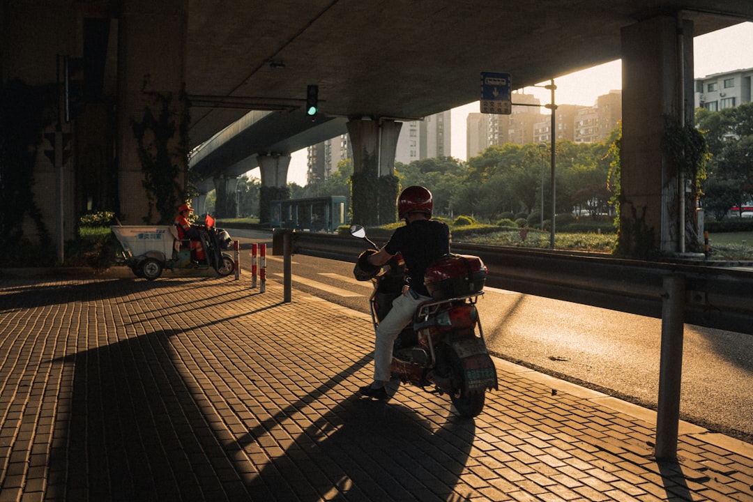 man in black jacket riding on red motorcycle during daytime