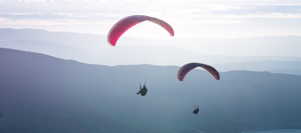 red and white parachute over the sea