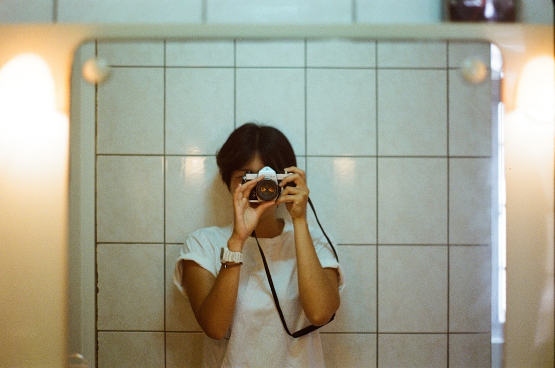 woman in white t-shirt taking photo