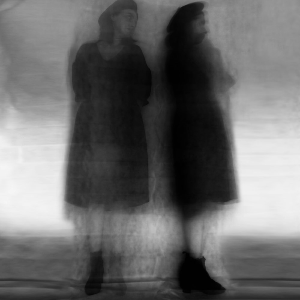 grayscale photo of 2 women standing on road