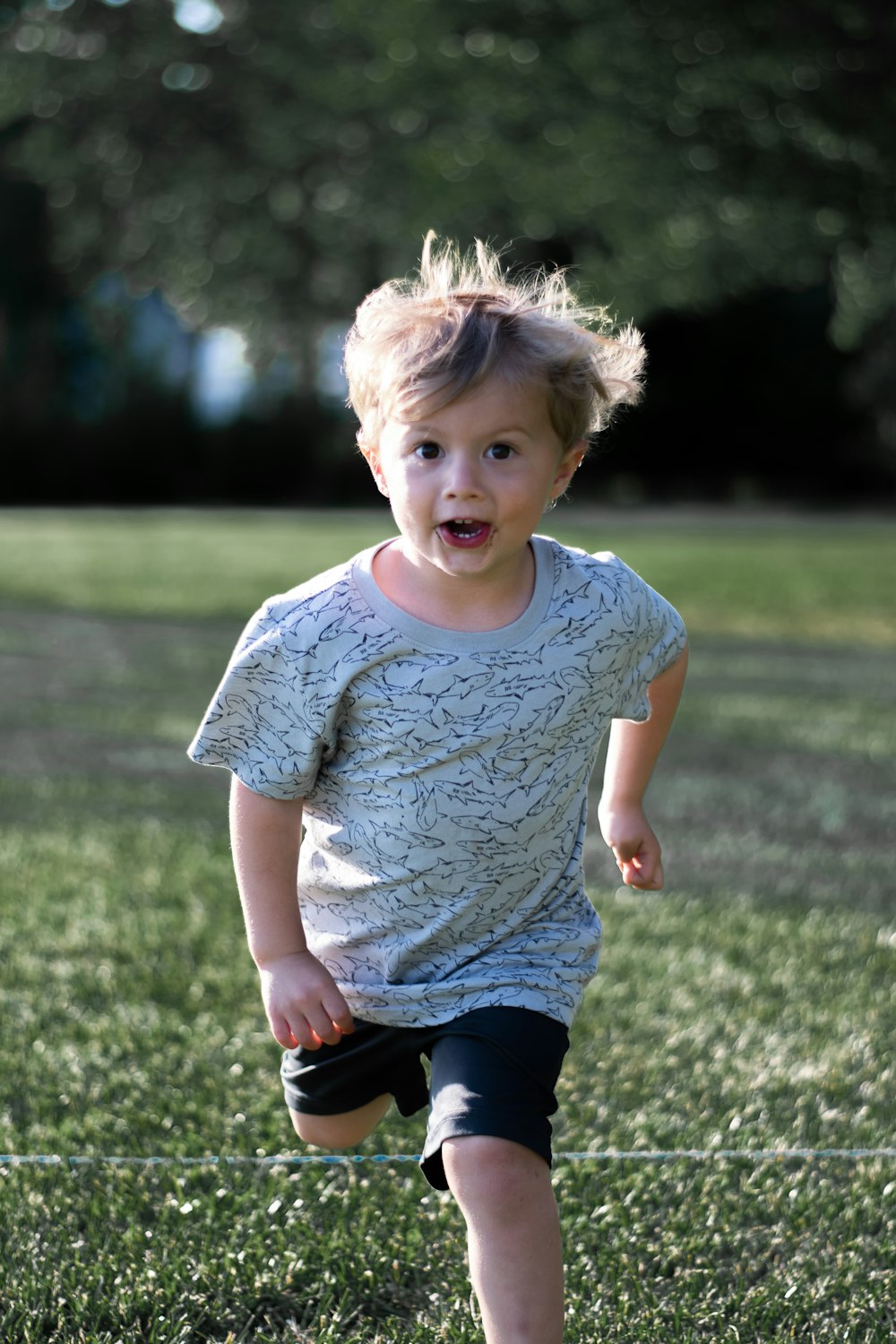 girl in white crew neck t-shirt and black pants standing on green grass field during