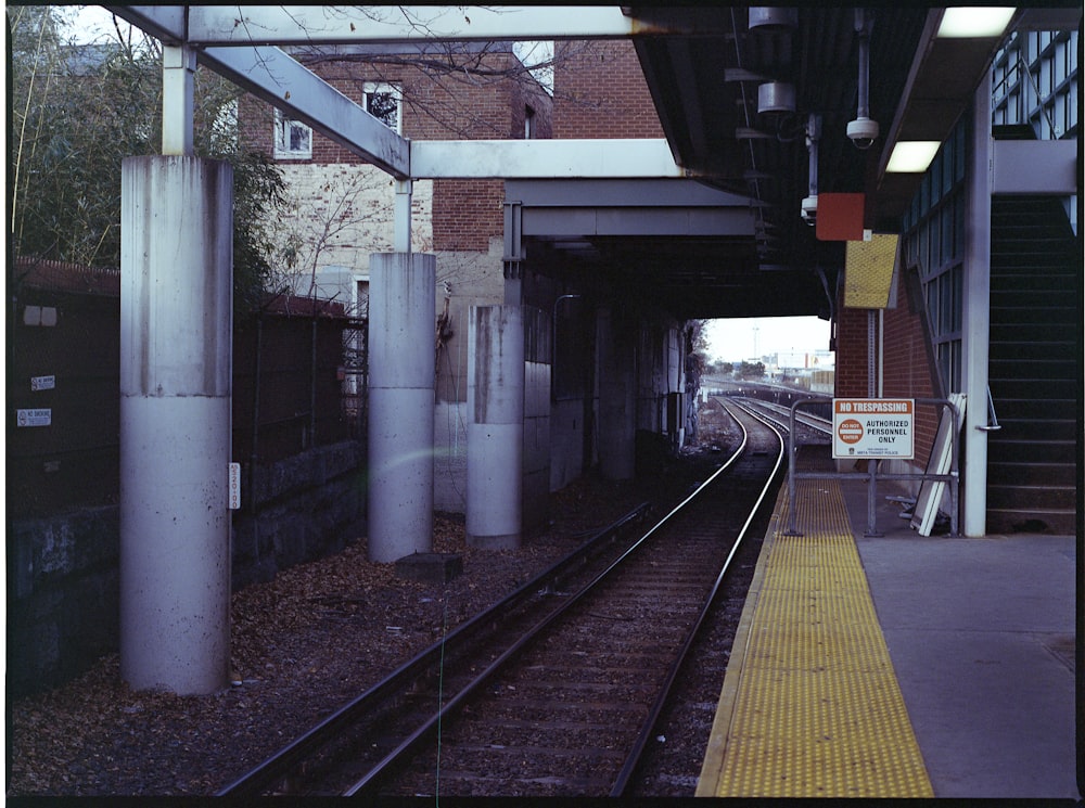 train rail near white concrete building during daytime