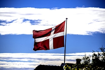 red and white flag on pole under blue sky during daytime