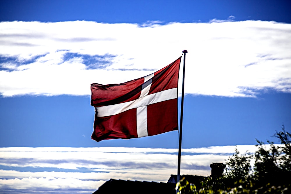 red and white flag on pole under blue sky during daytime