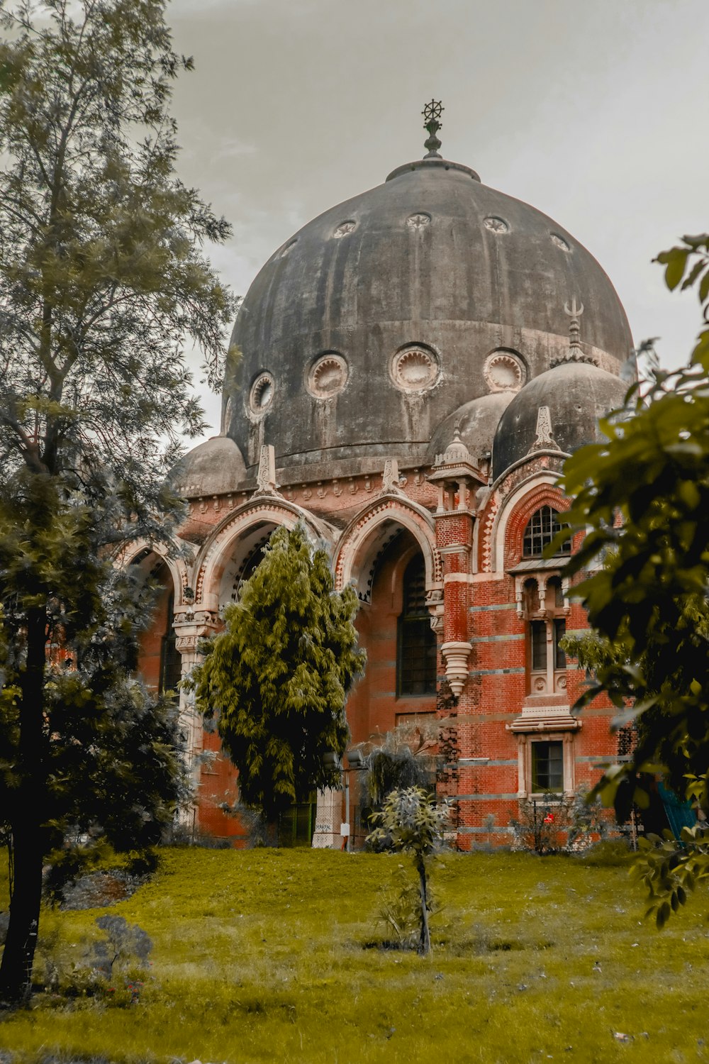 brown concrete dome building near green trees during daytime