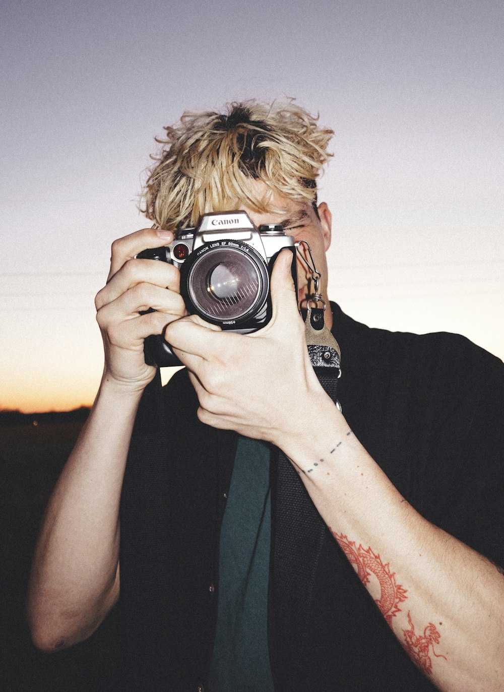 man in black shirt holding black and silver camera