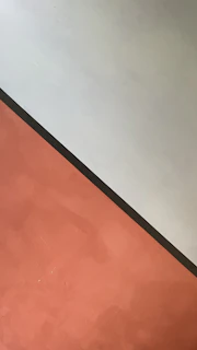 Close-up of sharp-edged solid color blocks in deep red and dark charcoal, highlighting minimalist navigation.