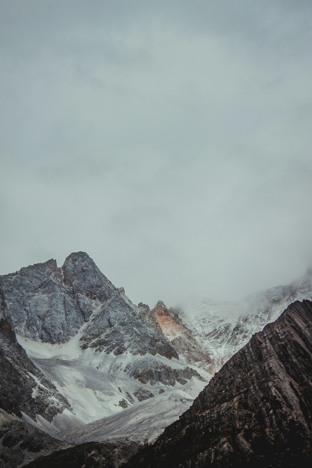 snow covered mountain under cloudy sky during daytime