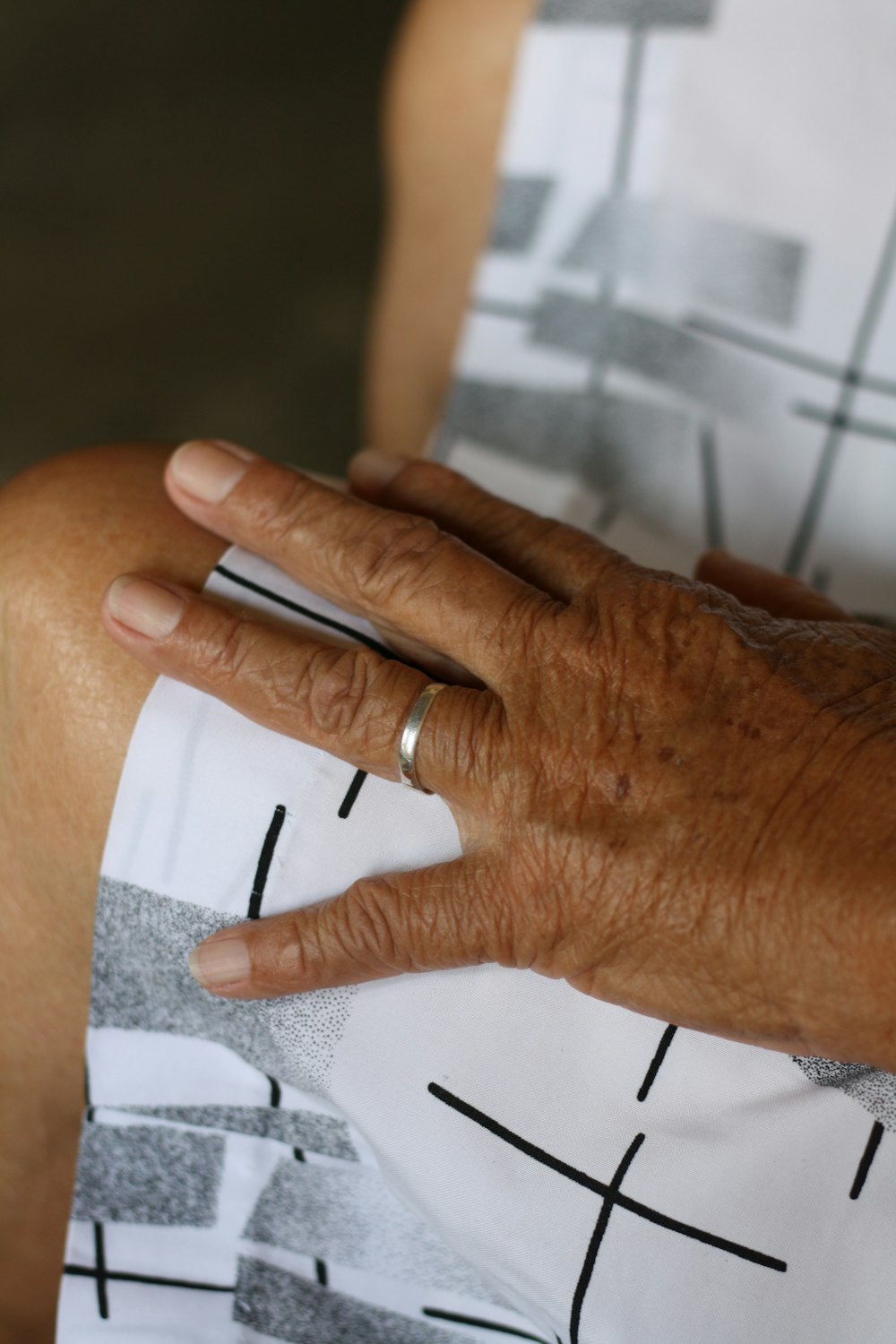 person wearing silver ring on white paper