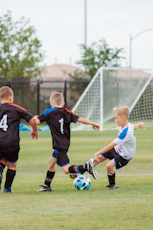 2 men playing soccer during daytime