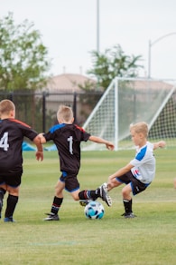 2 men playing soccer during daytime