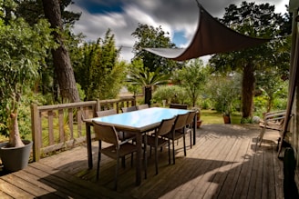 brown wooden table with chairs and umbrella