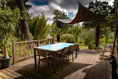 brown wooden table with chairs and umbrella