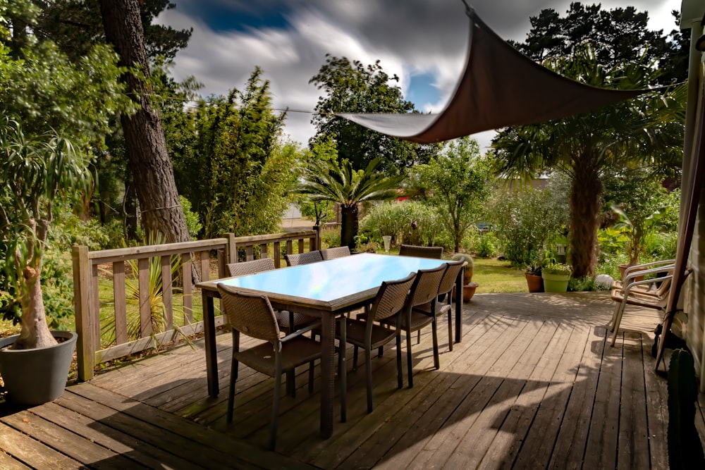 brown wooden table with chairs and umbrella