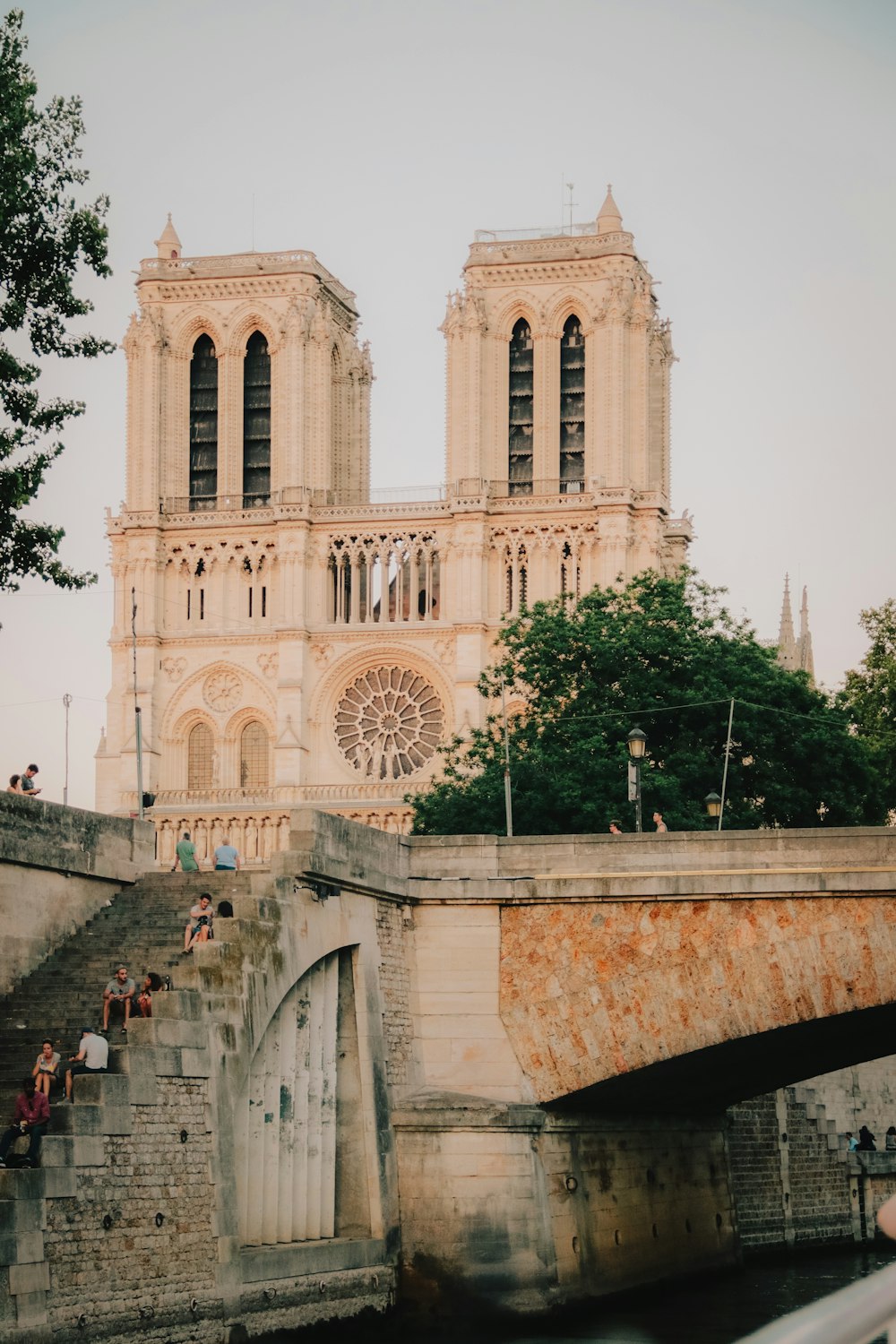 personnes marchant sur un pont près d’un bâtiment en béton blanc pendant la journée