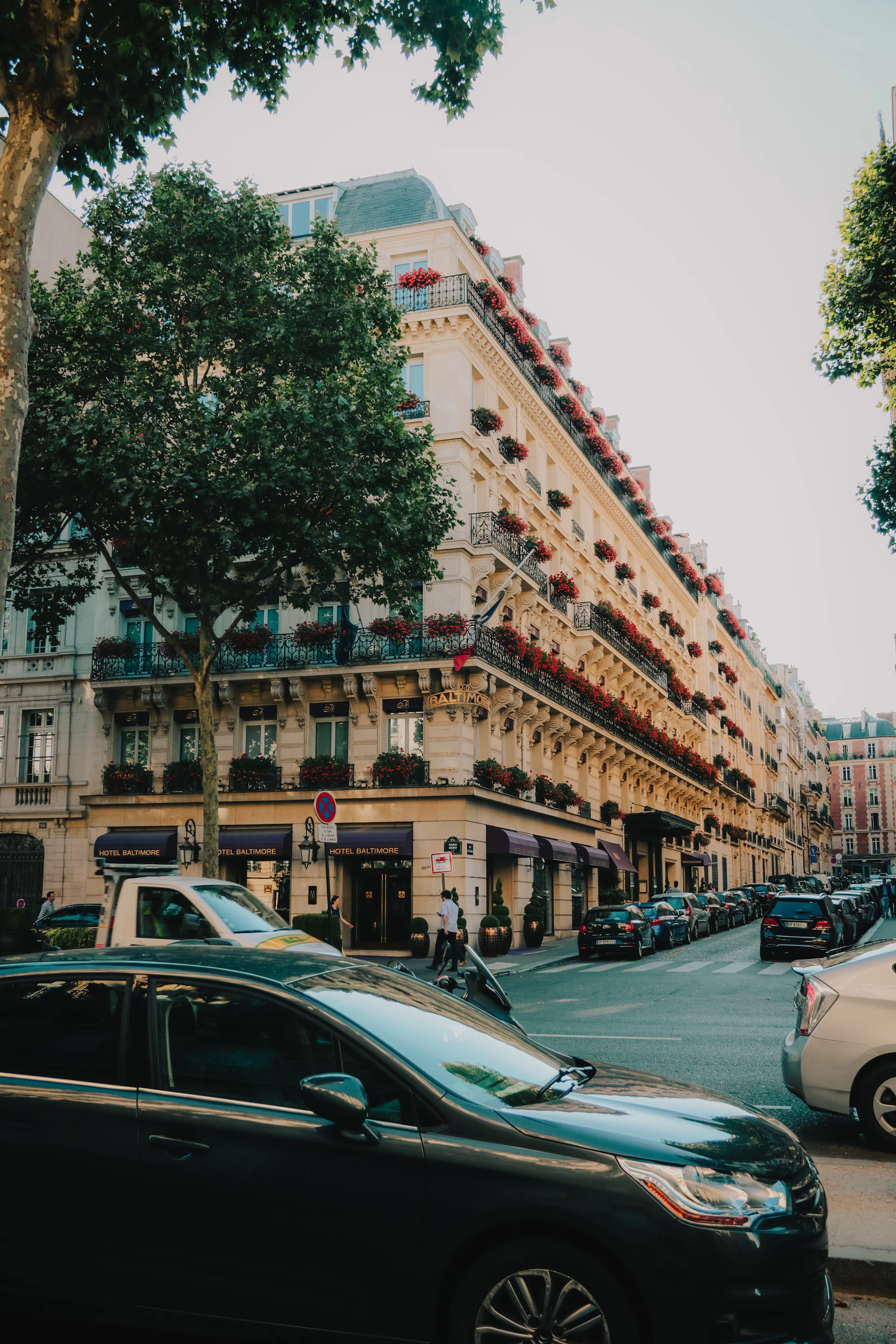 cars parked in front of brown concrete building during daytime