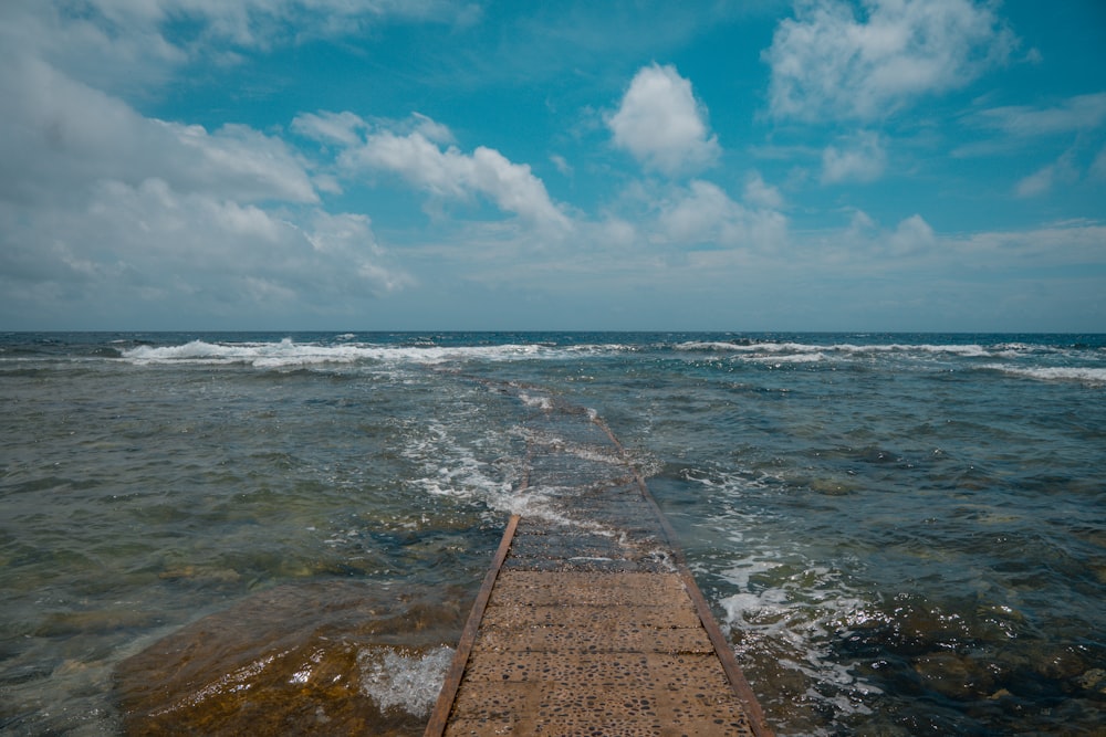 doca de madeira marrom no mar durante o dia