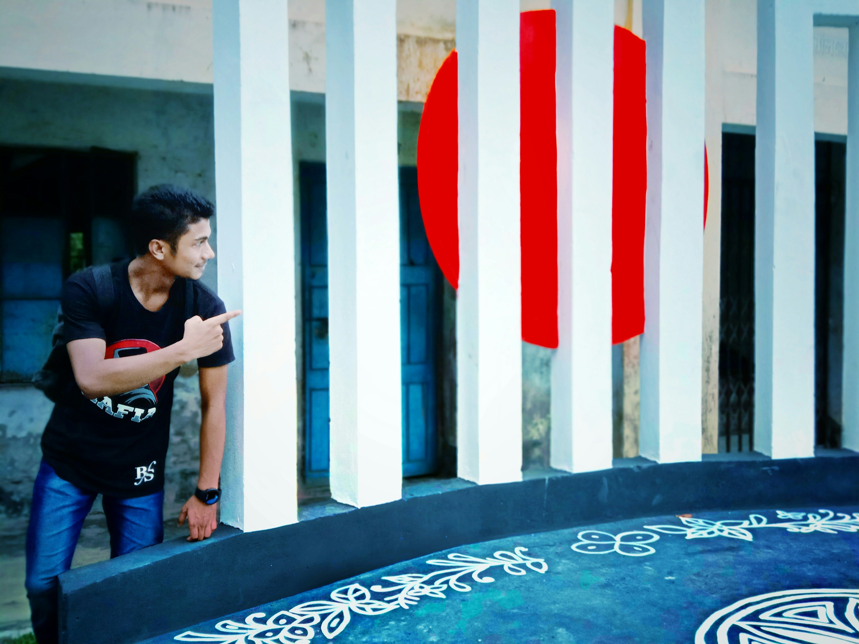 Anak laki-laki dengan kaos hitam berdiri di kolam renang bundar biru dan putih