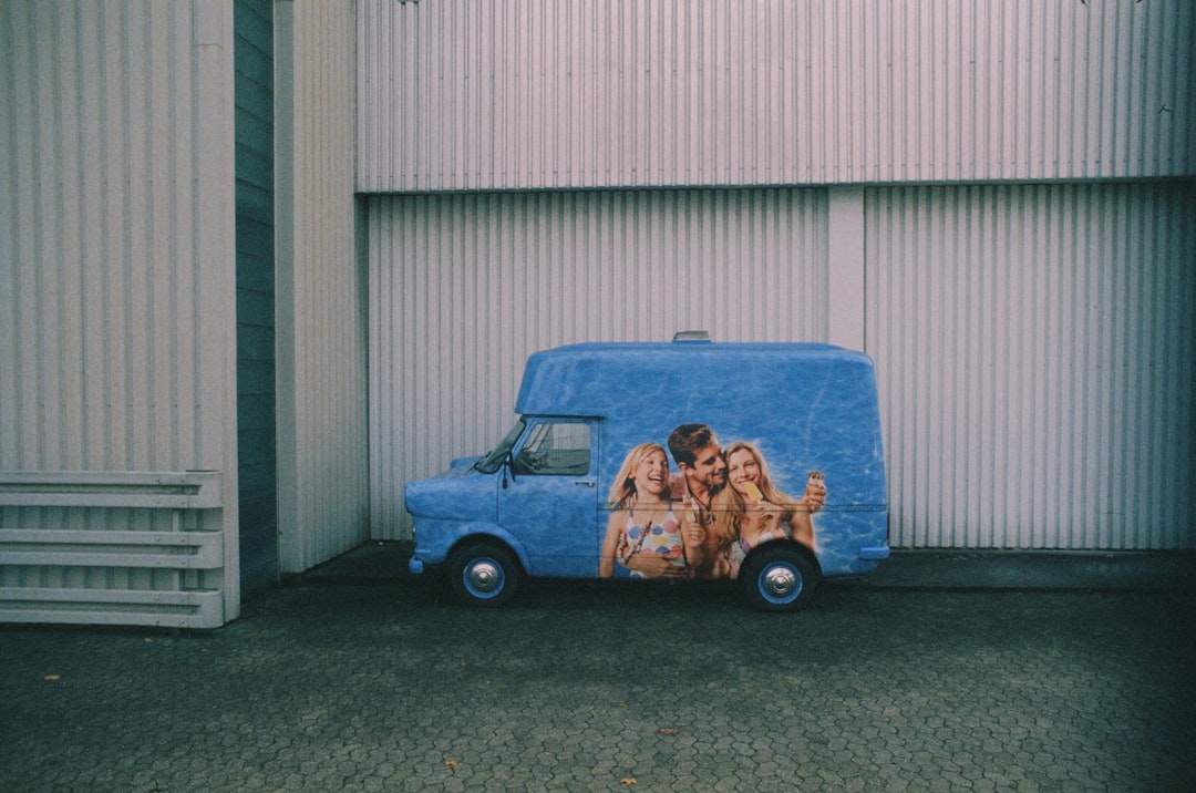 blue and brown car in front of white garage