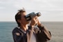 man in gray jacket holding black and white camera