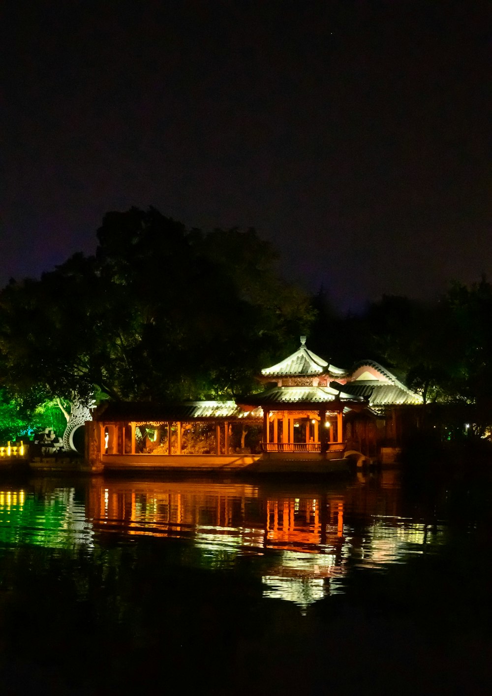 brown wooden house near green trees during night time