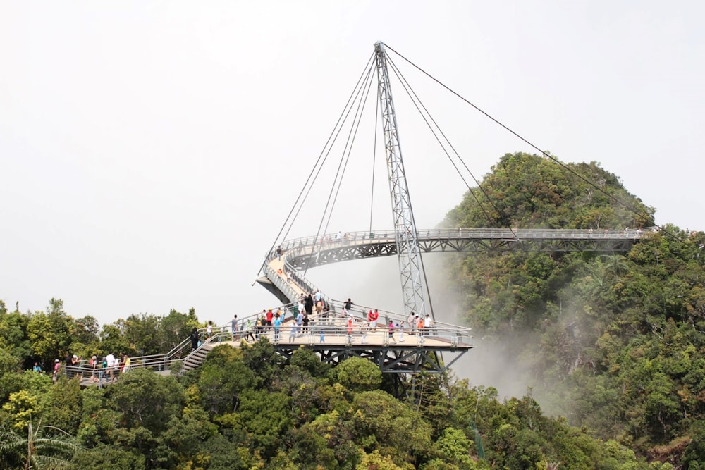 teleférico branco e preto sobre árvores verdes durante o dia