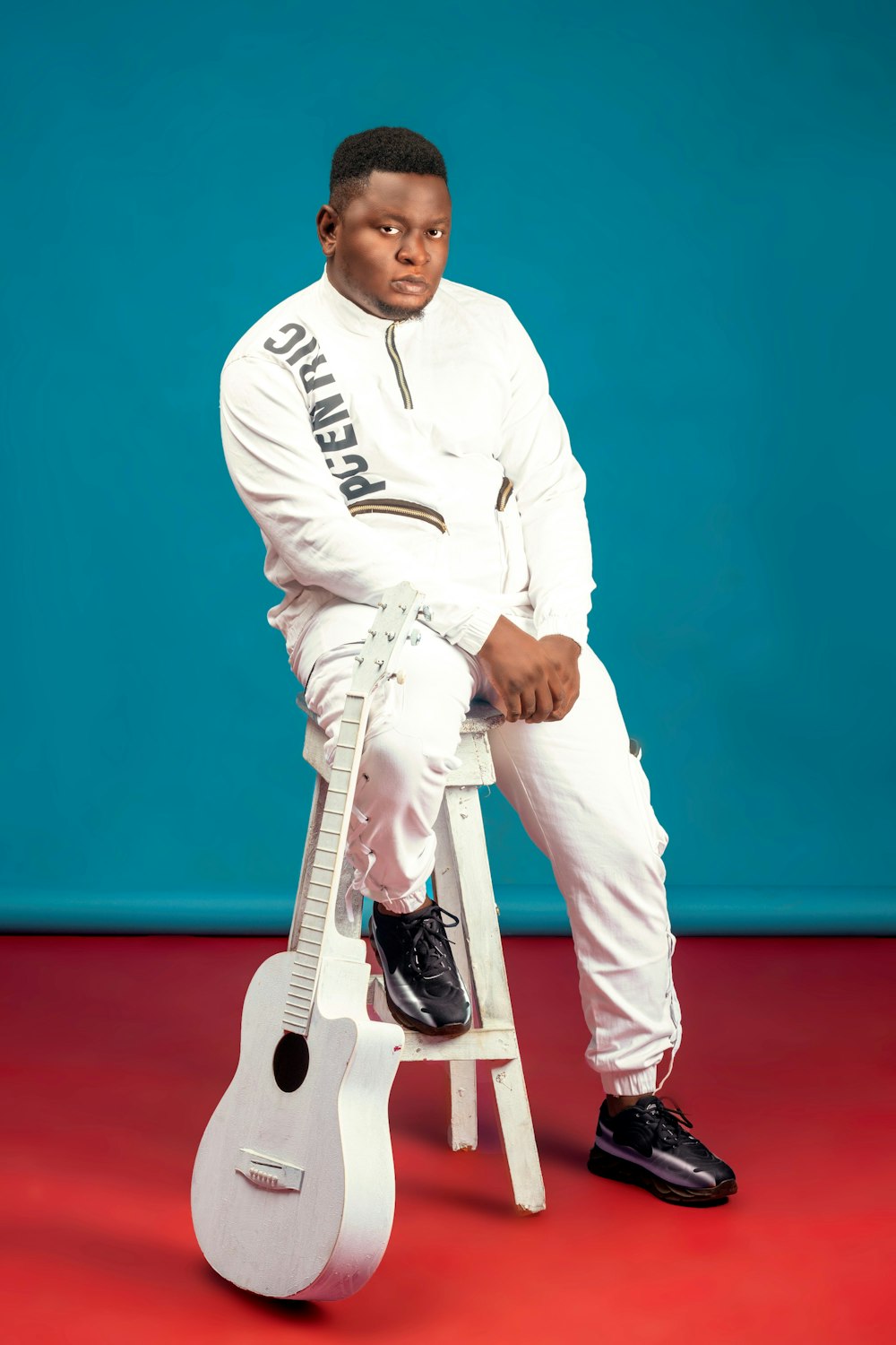 man in white long sleeve shirt and white pants sitting on white seat