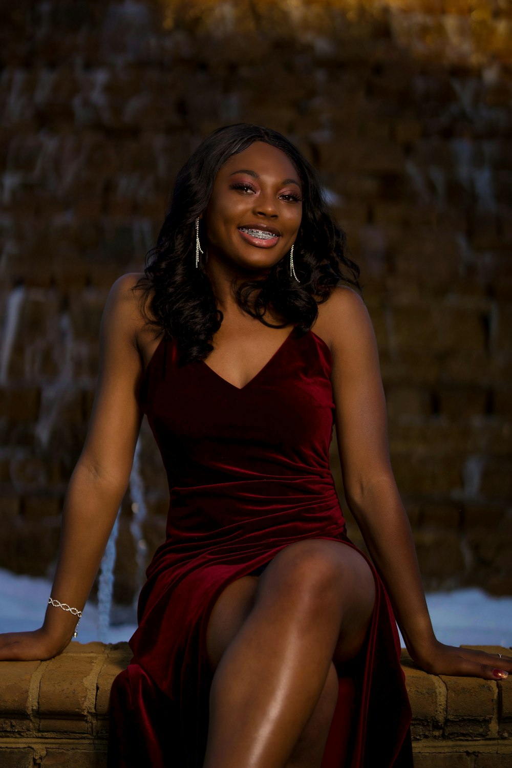 woman in red sleeveless dress sitting on brown wooden chair