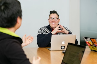 people in a meeting with laptops in front of them 