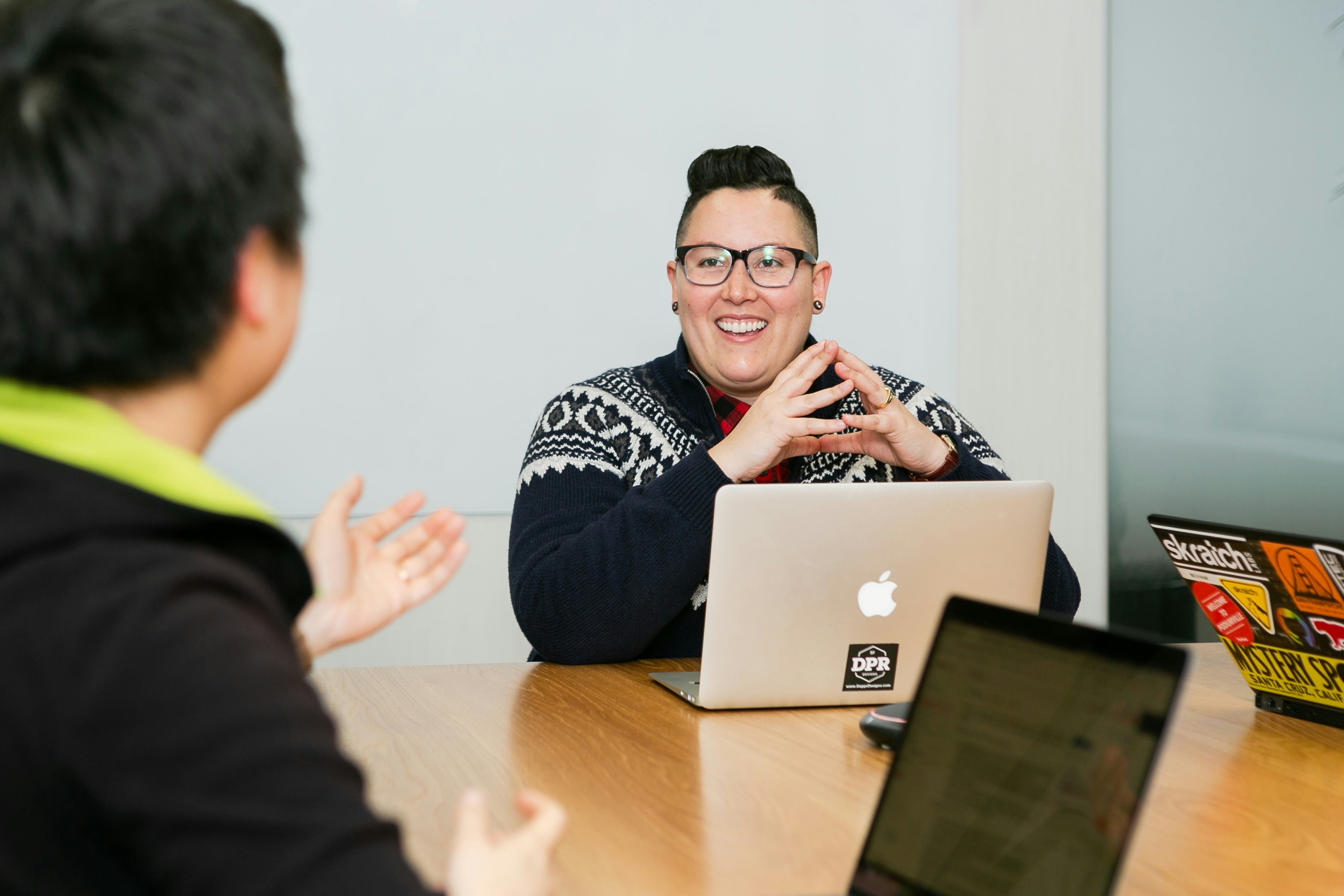 people in a meeting with laptops in front of them 