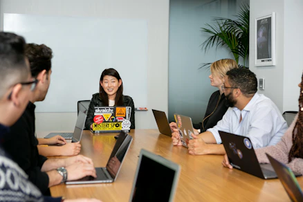 A team meeting discussing strategy with laptops and charts.