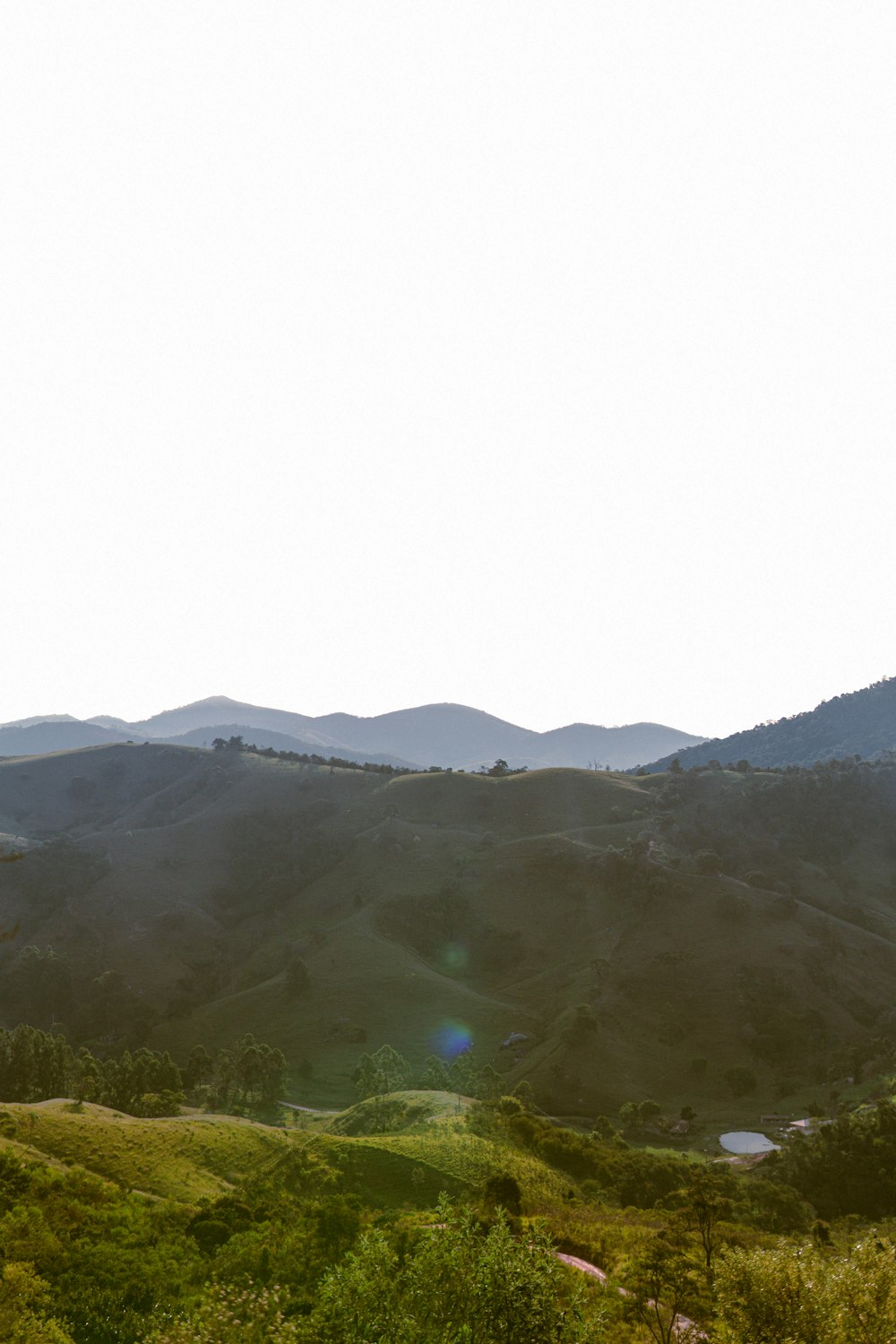 campo di erba verde e montagne durante il giorno