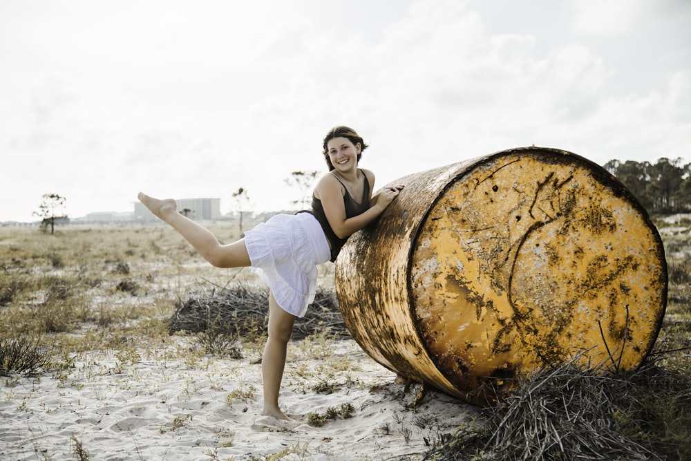 woman in white t-shirt and white shorts sitting on brown wooden barrel