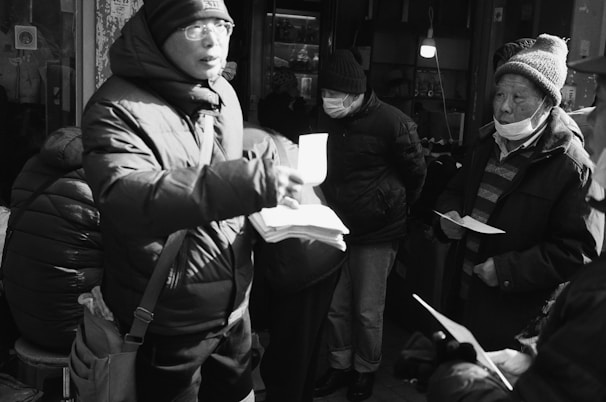 Volunteers handing out warm clothes to individuals during a cold season drive.