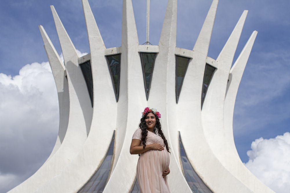 woman in white dress standing near white concrete wall during daytime