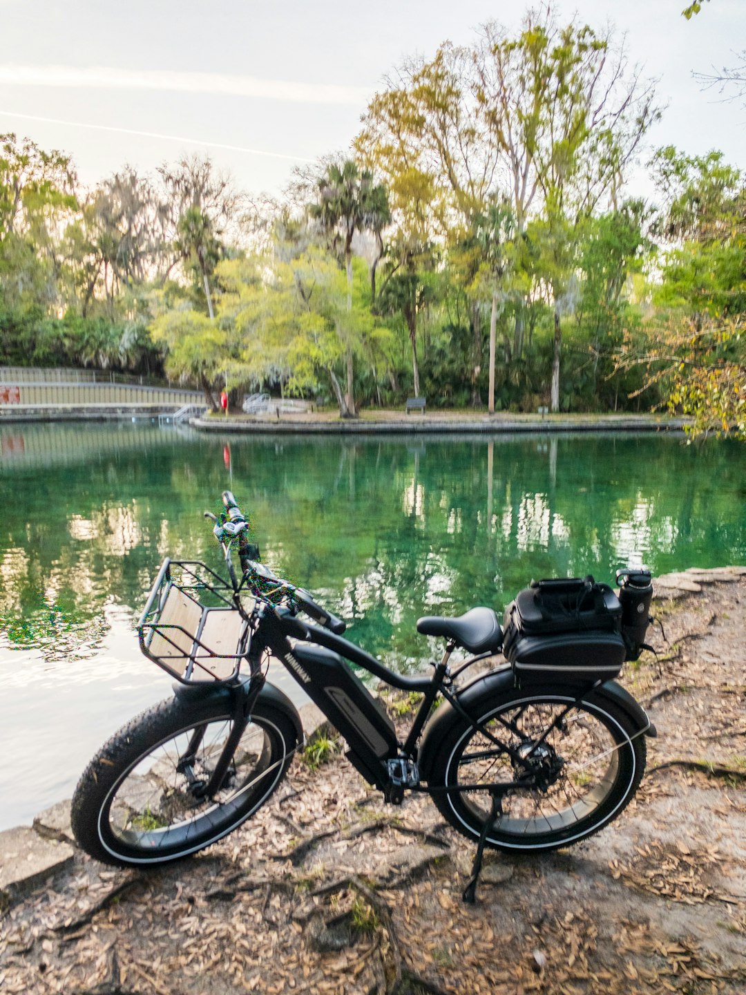 black motorcycle parked beside river during daytime