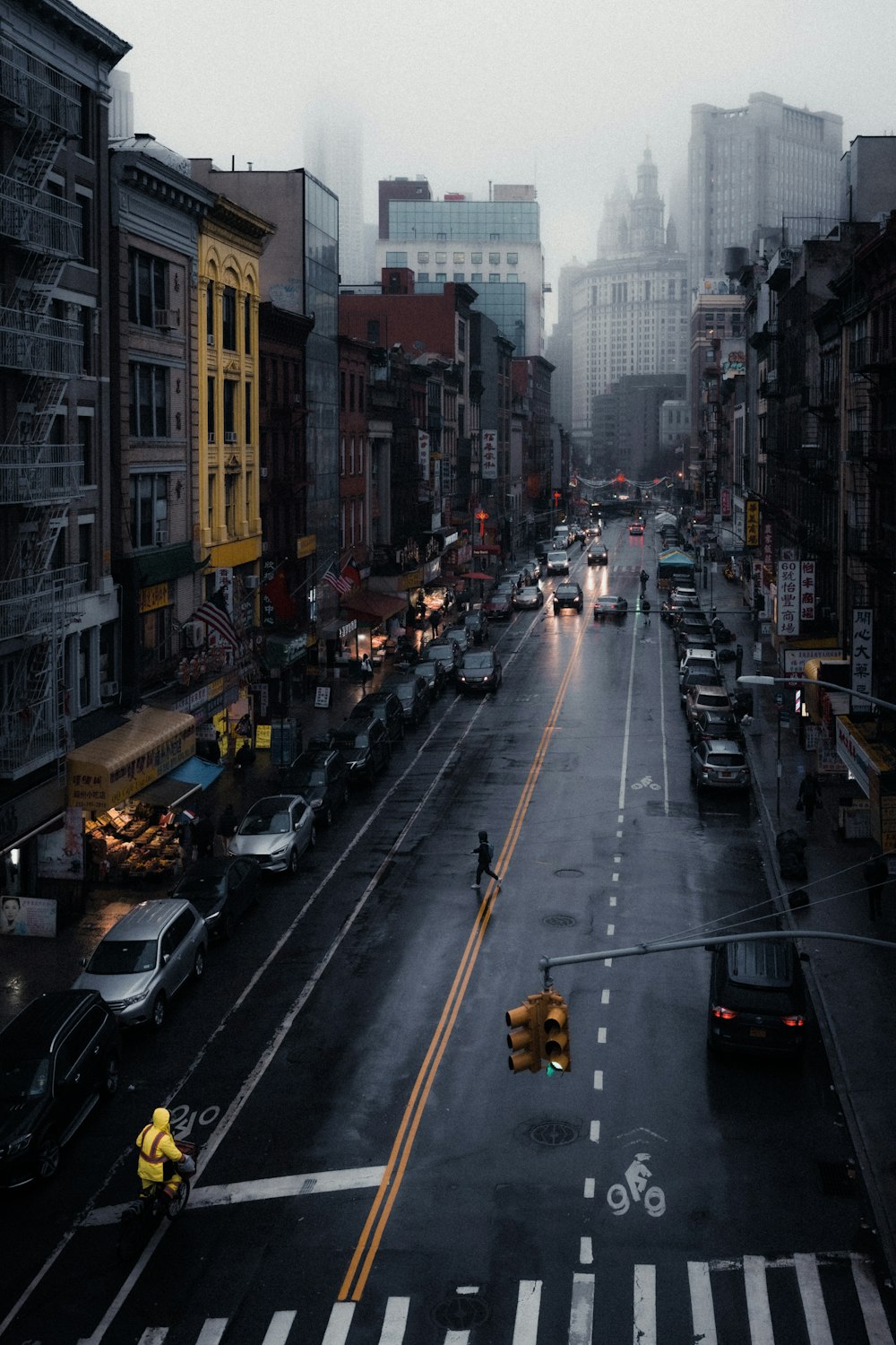 cars on road between high rise buildings during daytime