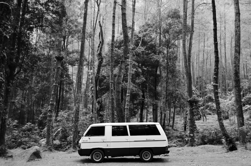 grayscale photo of van in forest