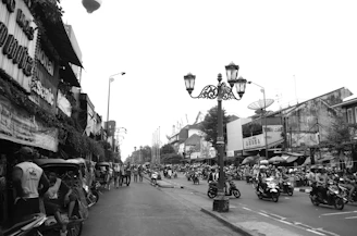 grayscale photo of people riding motorcycle on road