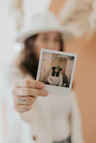 An artist’s hand gently holding a freshly printed photo with subtle shadows emphasizing the print’s quality.