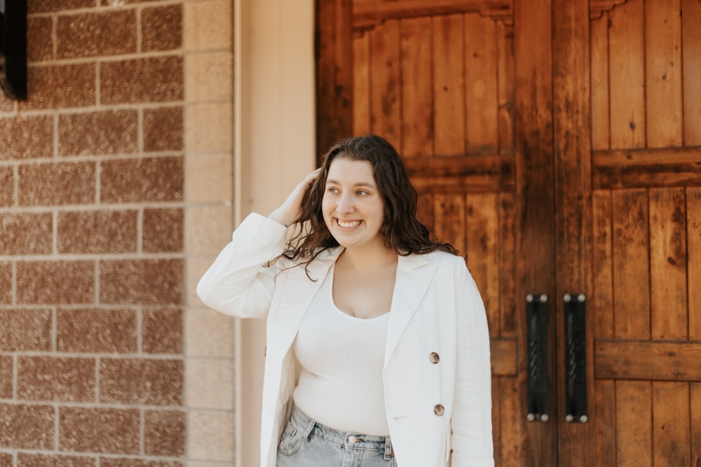 woman in white long sleeve shirt and blue denim daisy dukes standing beside brown wooden door