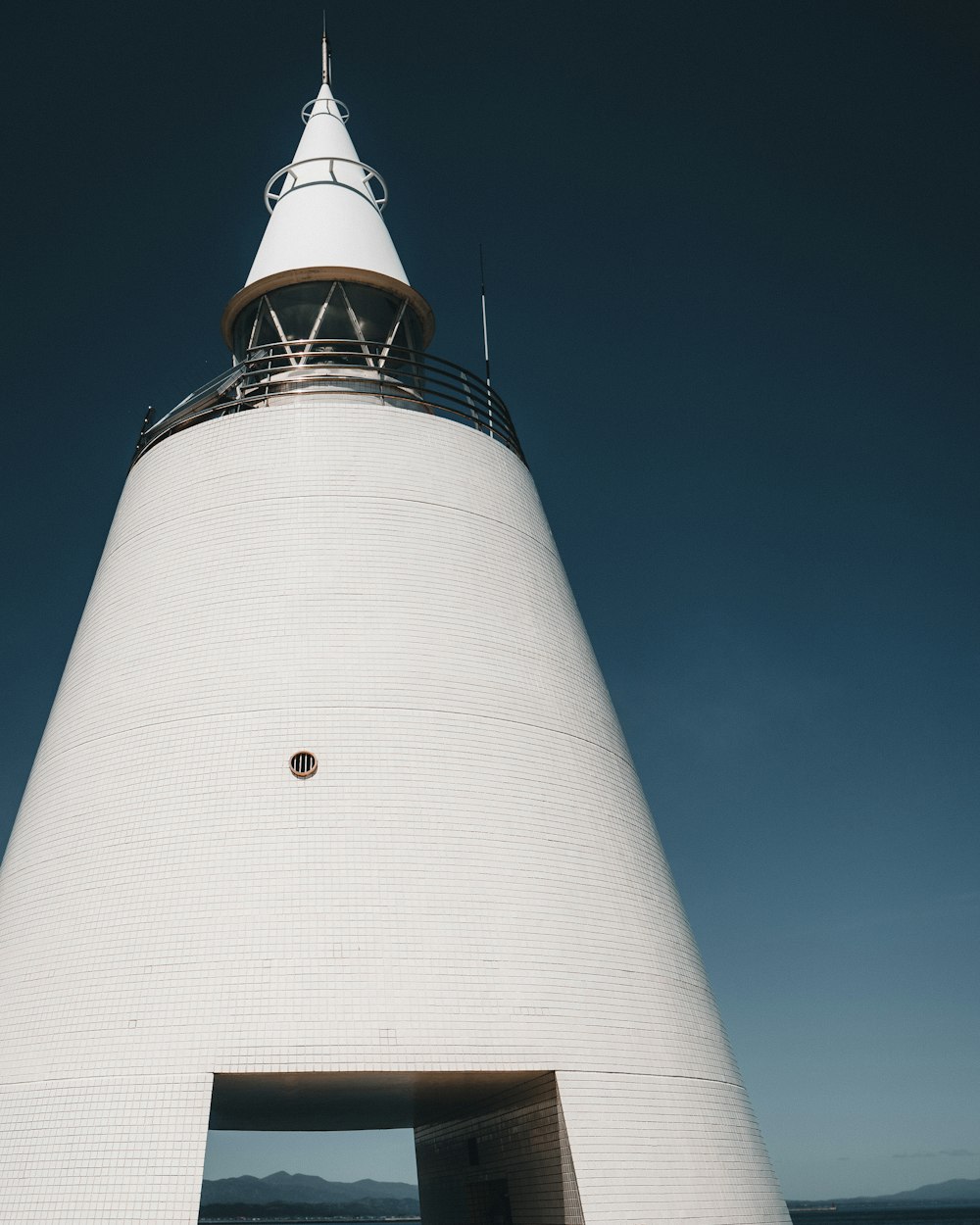 white and black concrete lighthouse under blue sky during daytime