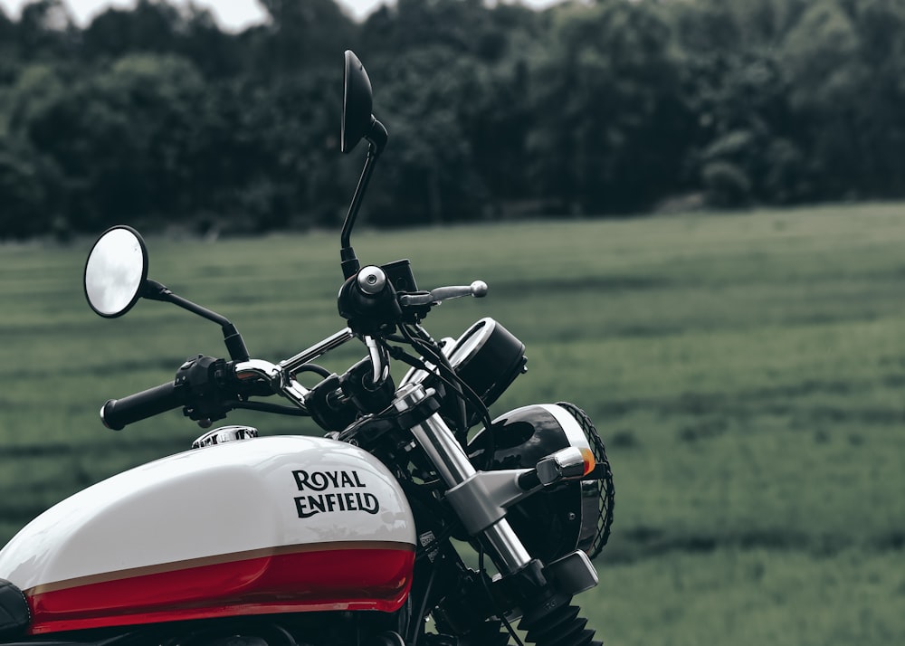 red and white honda motorcycle on green grass field during daytime
